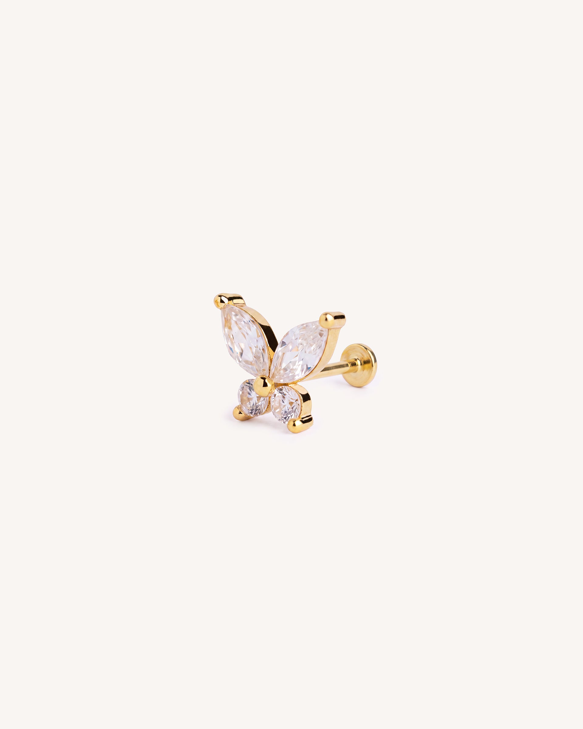 A gold flatback butterfly labret stud earring featuring marquise-cut and round clear gemstones, shown on a plain off-white background.