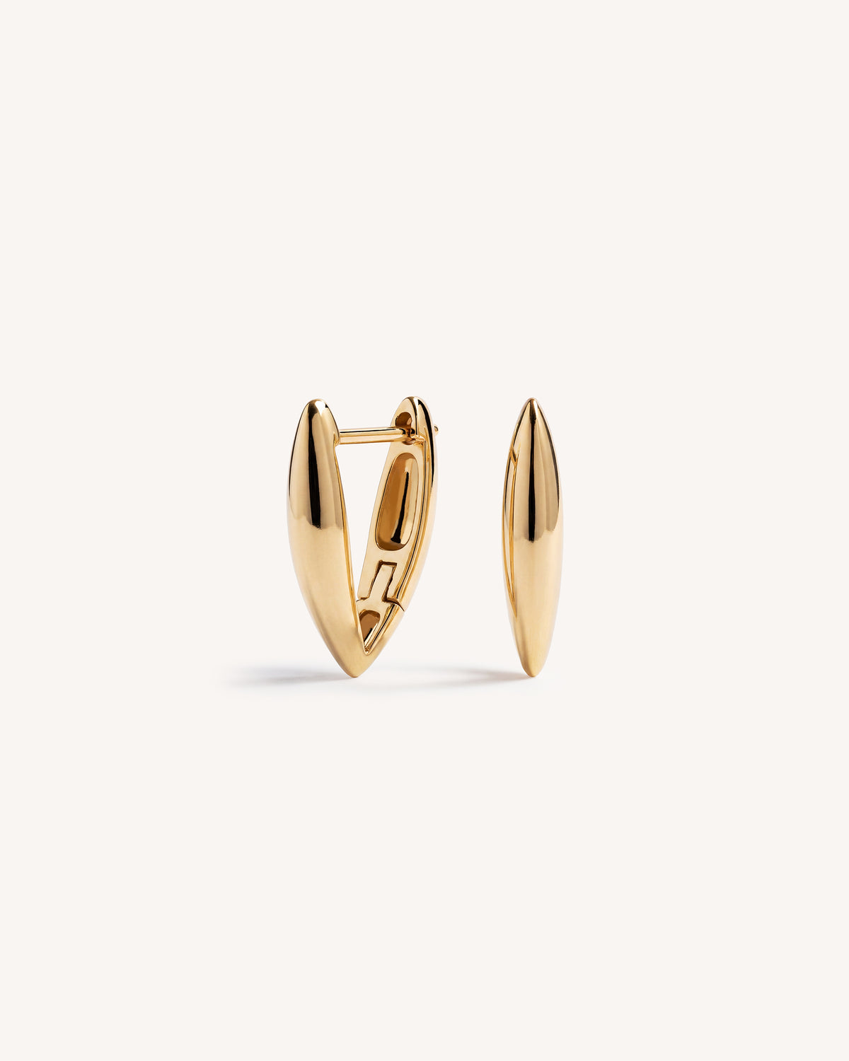 A pair of gold huggie hoop earrings with a polished, elongated teardrop shape, displayed on a clean off-white background.