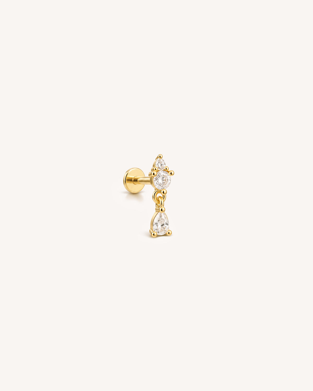 An 18k gold plated over sterling silver flatback labret stud piercing with clear CZ stones agains a white background.