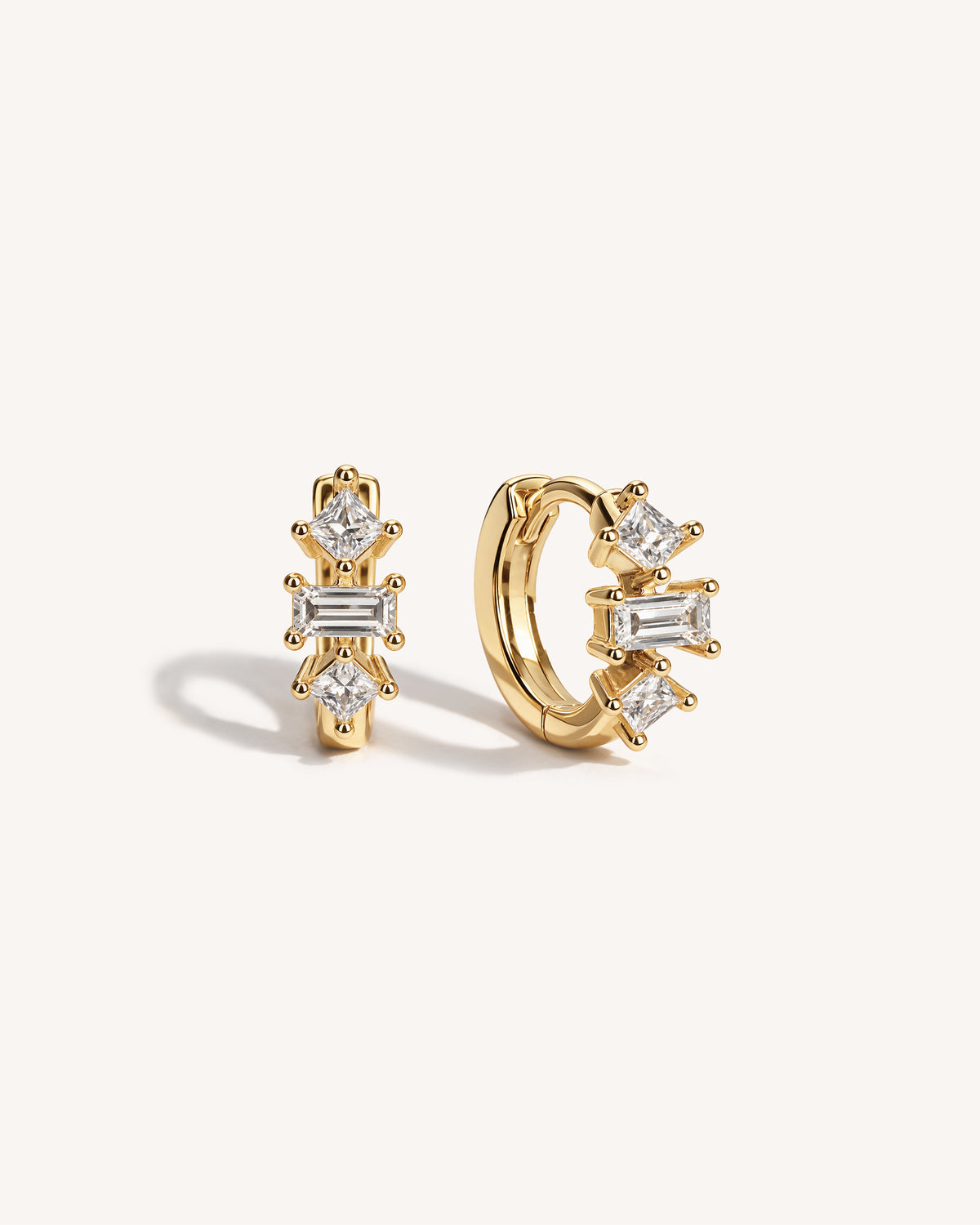 Baguette Trinity Huggie Hoops in Gold — 18k gold-plated sterling silver huggie earrings with baguette and princess-cut crystals