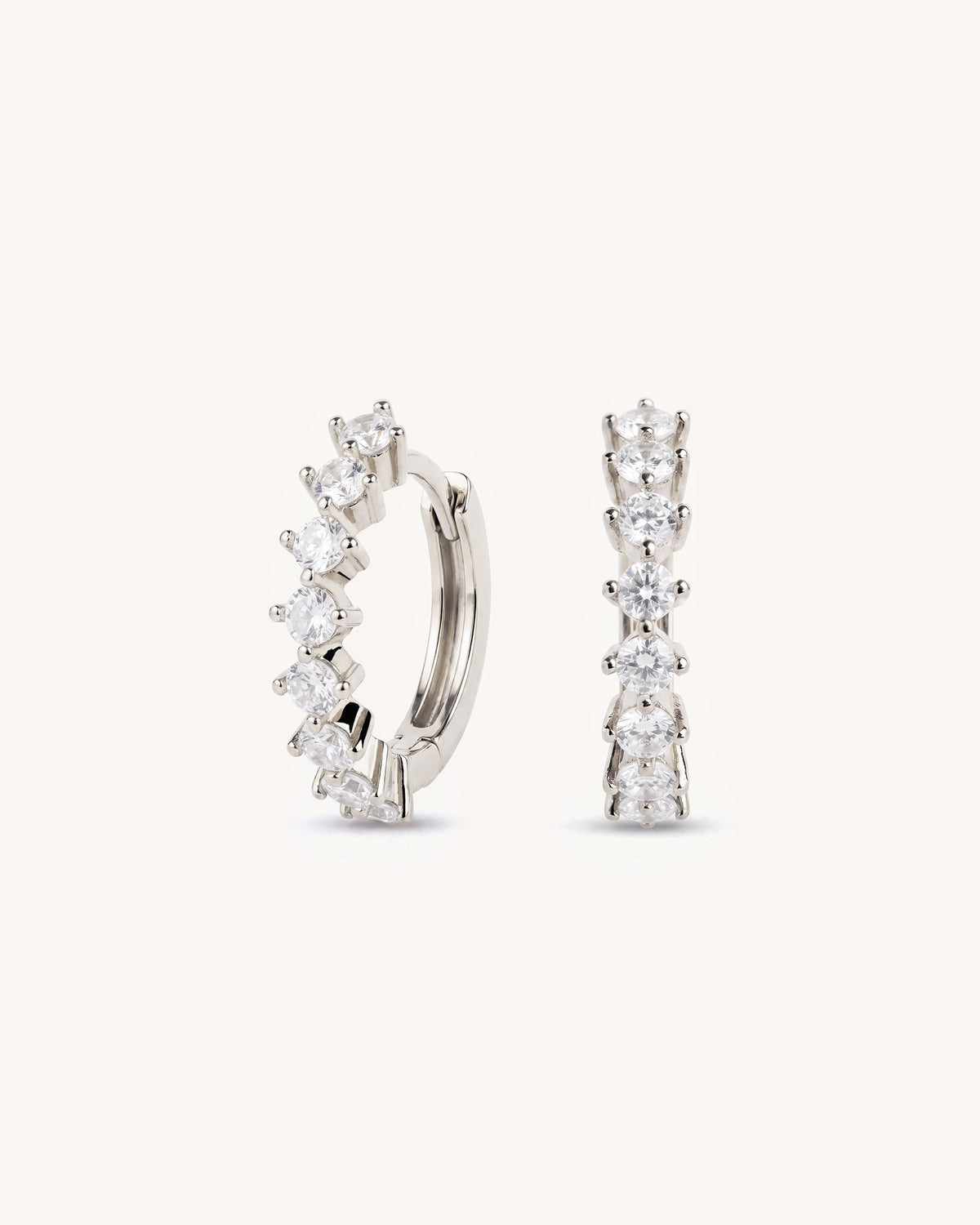 A pair of tennis 925 silver hoop earrings with a row of clear cubic zirconia stones, displayed on a clean off-white background.