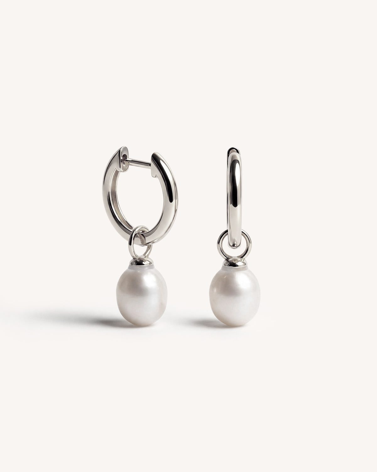 A pair of 925 silver hoop earrings with dangling white freshwater pearls, shown against a clean off-white background.