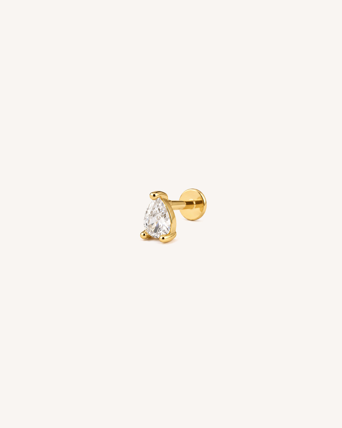 A single 18k gold plated flatback labret stud earring featuring a pear-cut clear gemstone in a prong setting, shown against a solid off-white background.